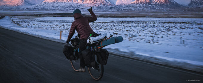 Cody Cirillo enjoys the frigid descent into the Troll Peninsula after a week of cycling through heinous winds, blizzards and ice roads. The reward at the end of the road? Gas station hot dogs, of course. Photo: Matthew Tufts